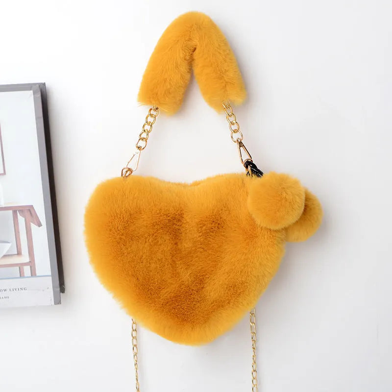 A soft plush heart-shaped women's handbag with a zipper and a detachable shoulder strap in a choice of 14 colours.