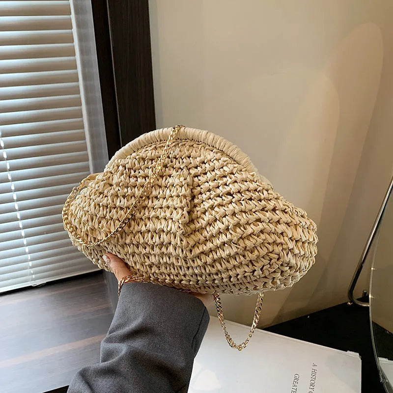 Beige shell-shaped straw shoulder bag with chain strap and woven texture.