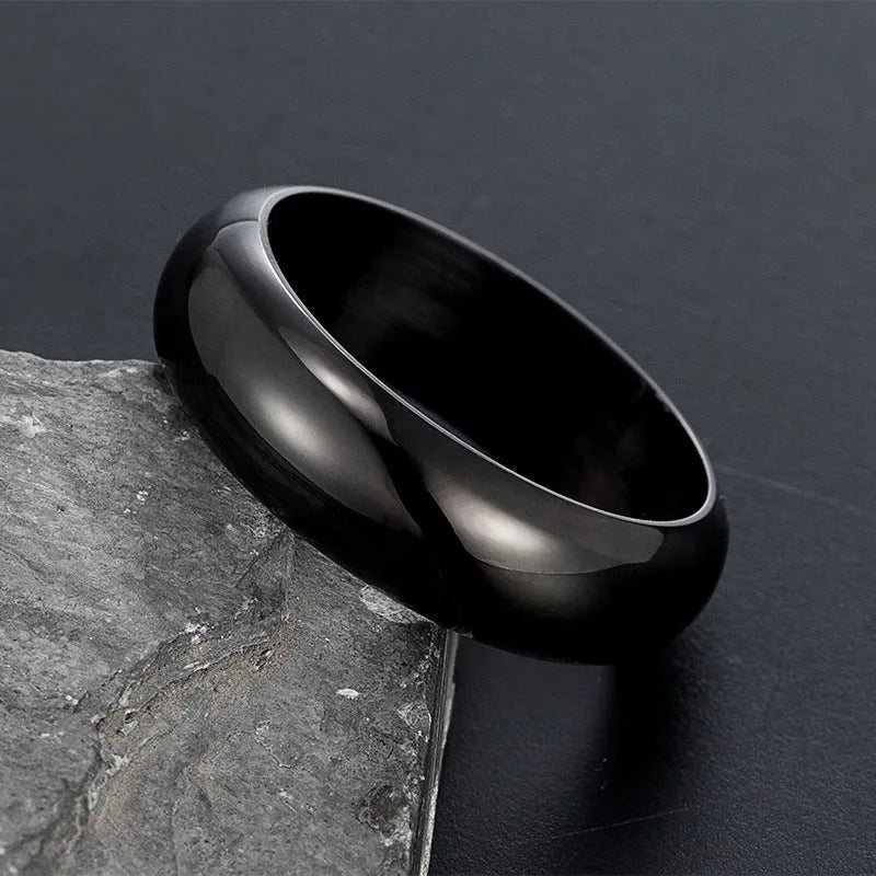 Glossy electroplated titanium steel ring in gold colour on a grey background.