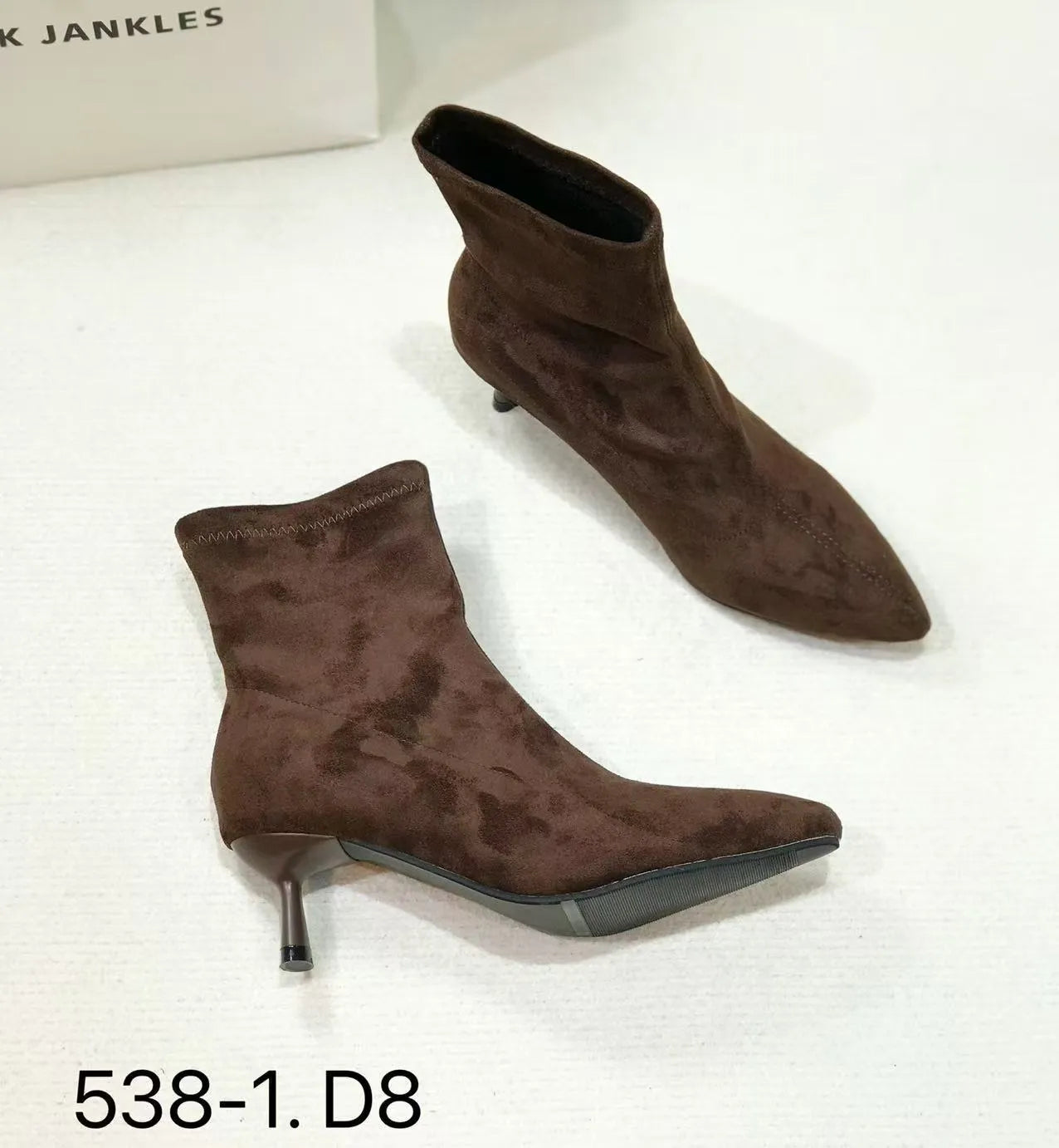 Black pointed toe women's ankle boots with a stiletto heel on a neutral background.