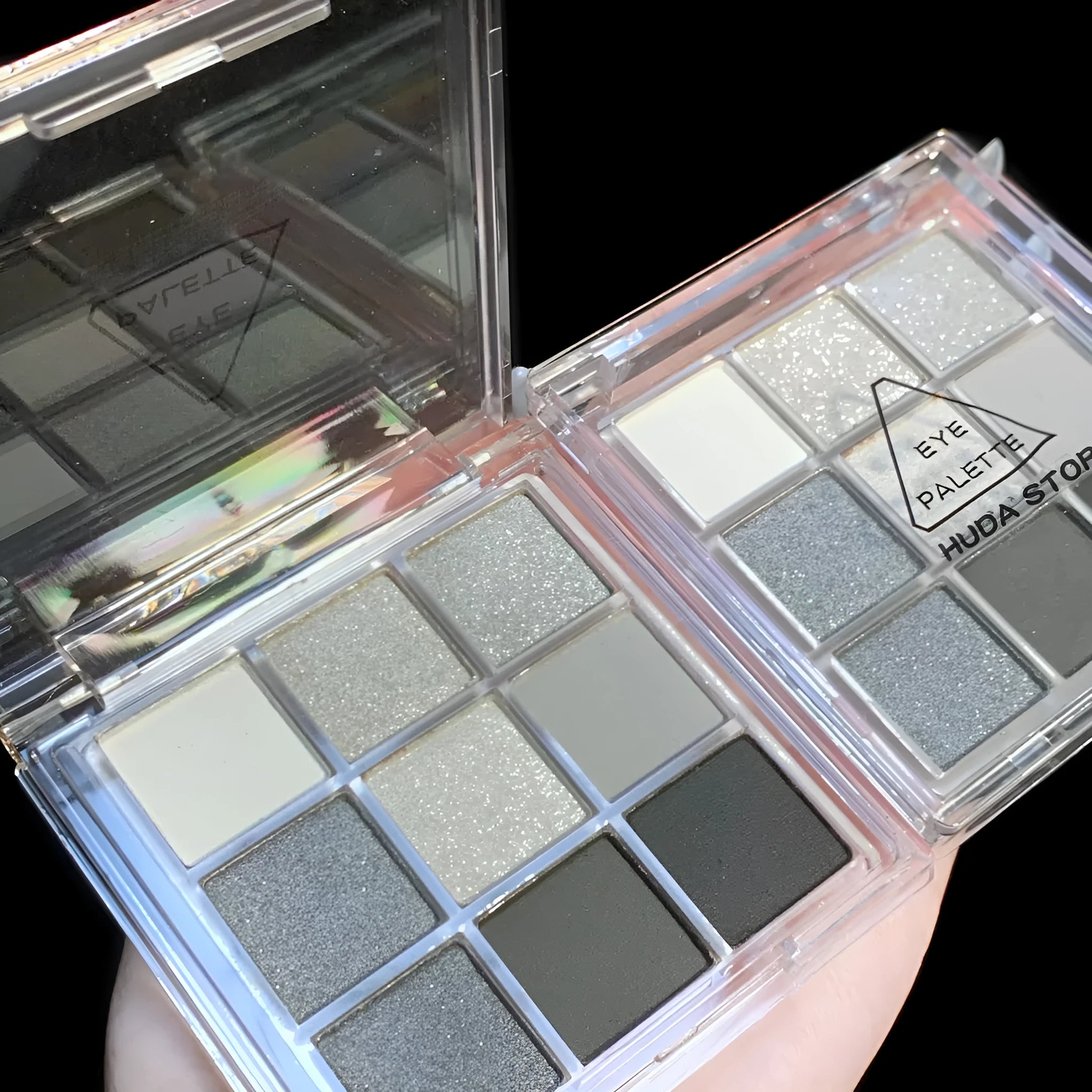 Nine-colour smoked eyeshadow palette showing white, silver, black, and iron grey shades in compact case