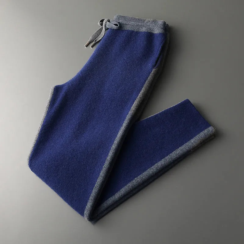 Men's navy blue cashmere blend knitted cardigan suit with half turtleneck and zip, paired with matching trousers.