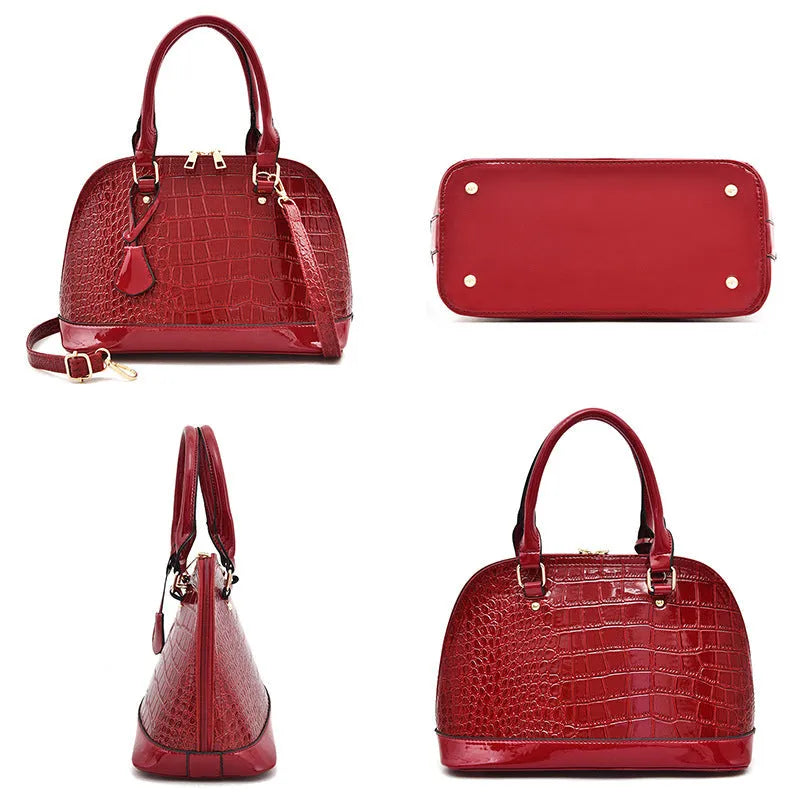 Large shiny PU crossbody shoulder bag in structured shell shape showing black, red, and brown colour options