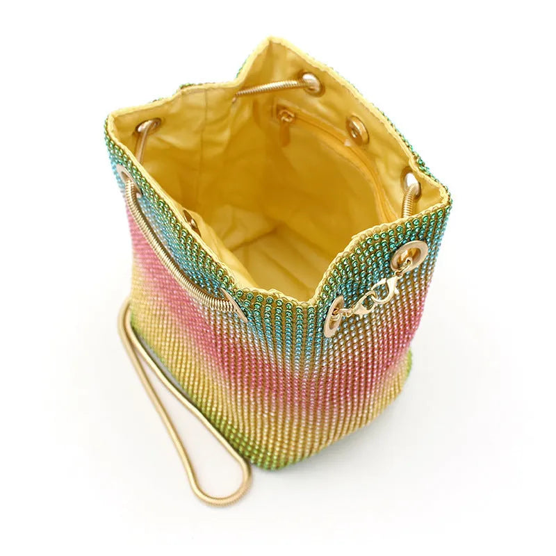 Rhinestone-decorated rainbow bucket bag with shoulder strap on a soft fabric base