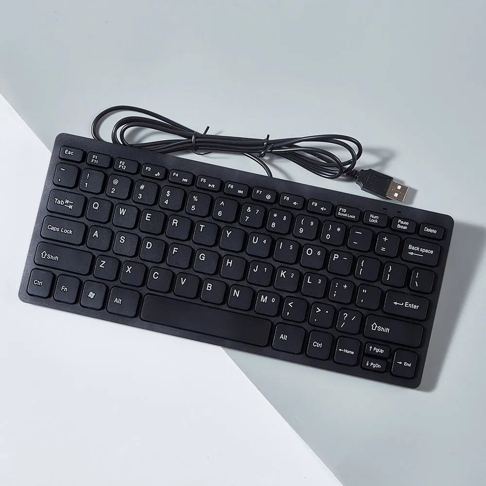 Compact black wired USB keyboard with noiseless keys on a desk.