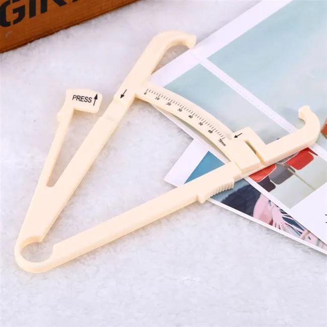 Clear acrylic body fat caliper showing measurement scales for skin fold thickness assessment