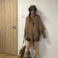 Women's triangular plush shawl cape with tassels in a cashmere and acrylic blend fabric.