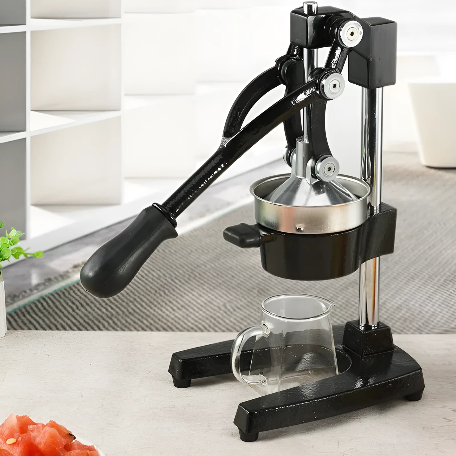 Black and white cast iron manual citrus juicer with stainless steel strainer, 40cm tall.