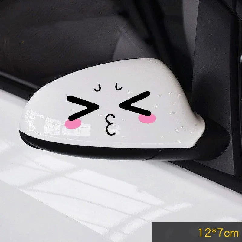 A pair of reflective cartoon eye car stickers on a vehicle rearview mirror.