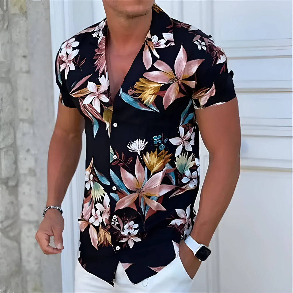 Man wearing a loose-fitting short-sleeve shirt with a colourful floral print pattern.
