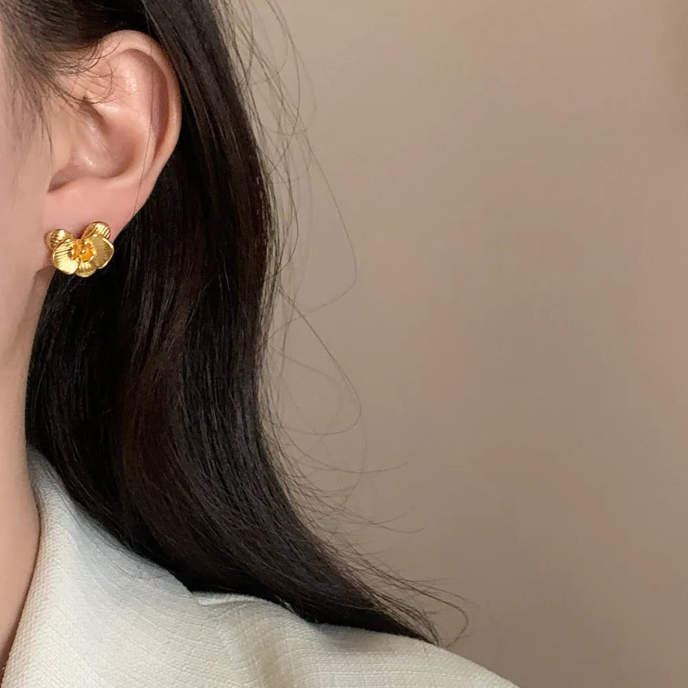 Retro flower earrings in gold or silver with detailed petal design on copper base