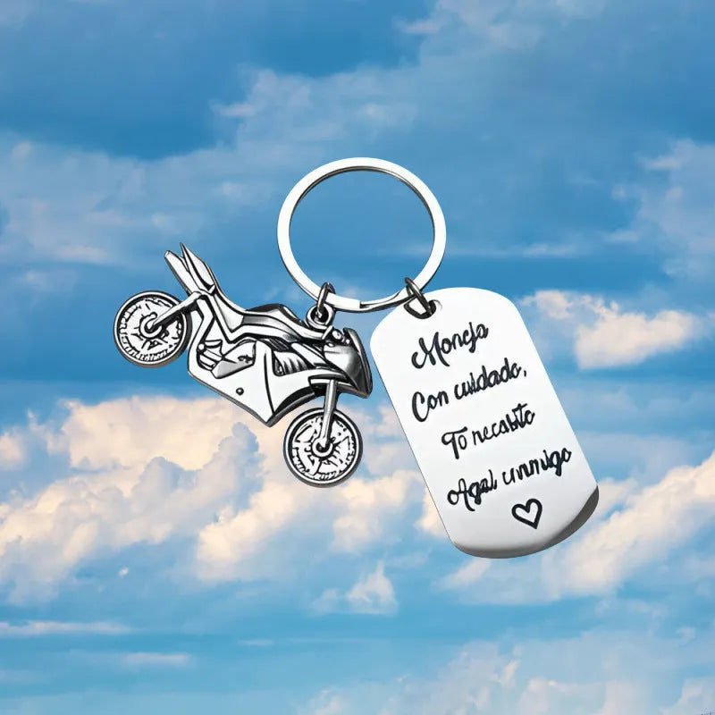 Stainless steel motorcycle keychain with inspirational design on a flannel bag.