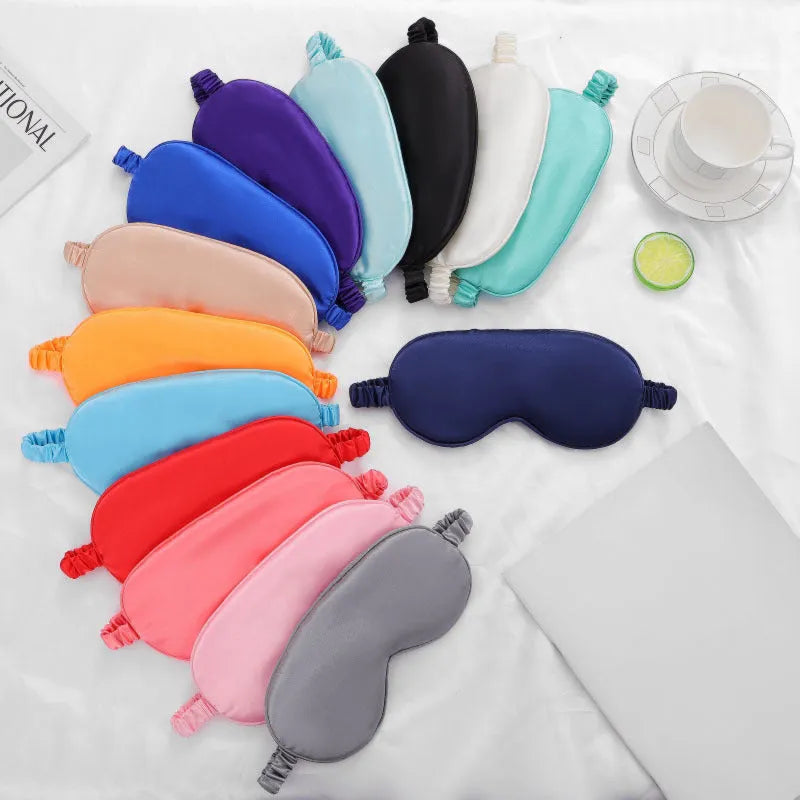 Double-sided Rayon elastic satin sleep mask shown in multiple colour options including sky blue, black, wine red, and light pink.