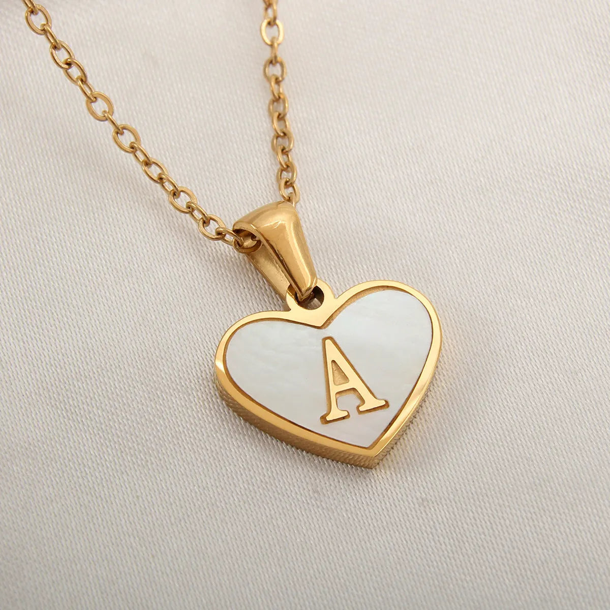 Gold plated heart-shaped necklace with white shell pendant on adjustable stainless steel chain