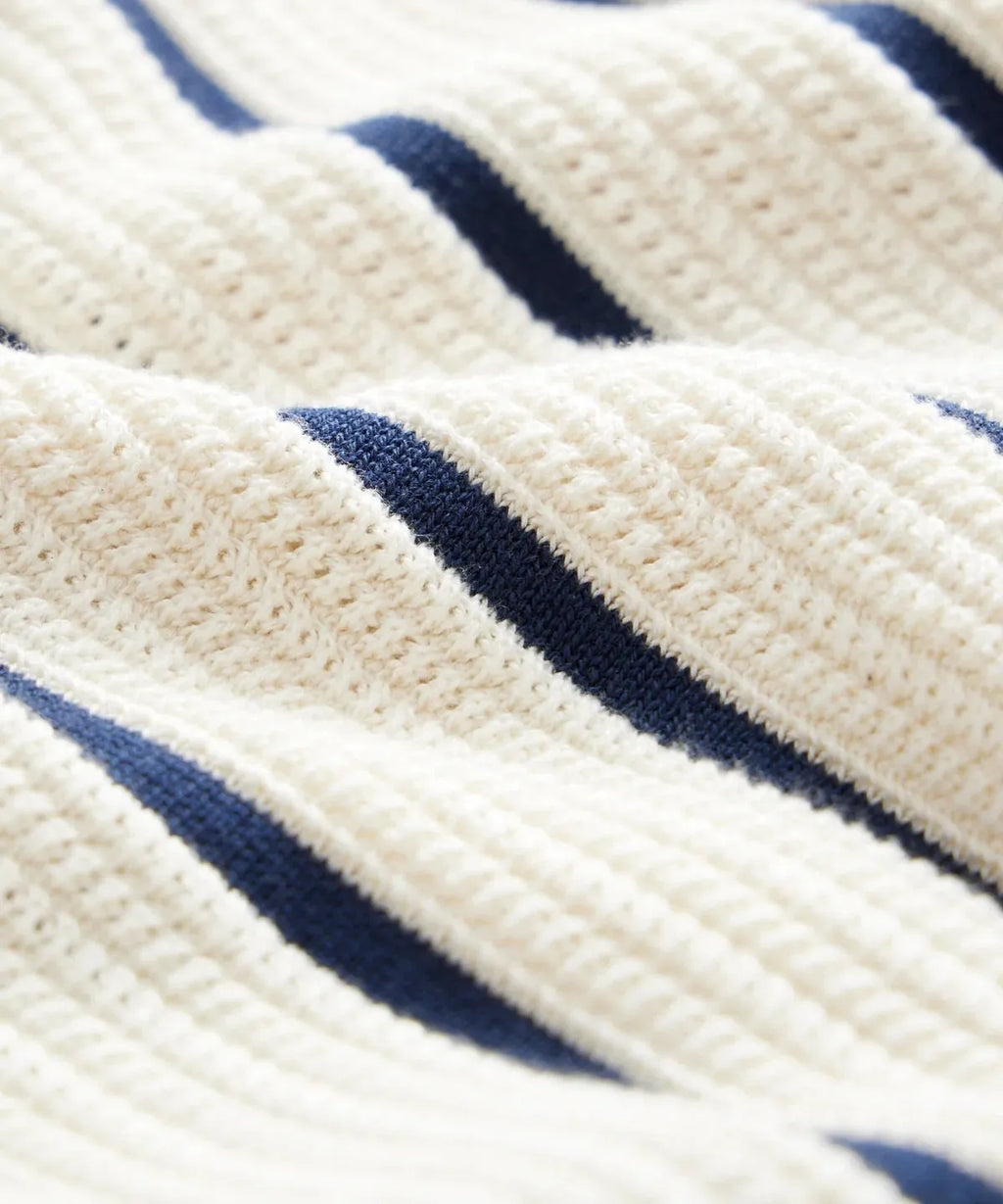 Men's white asymmetric lapel knitted top with short sleeves and a striped pattern.