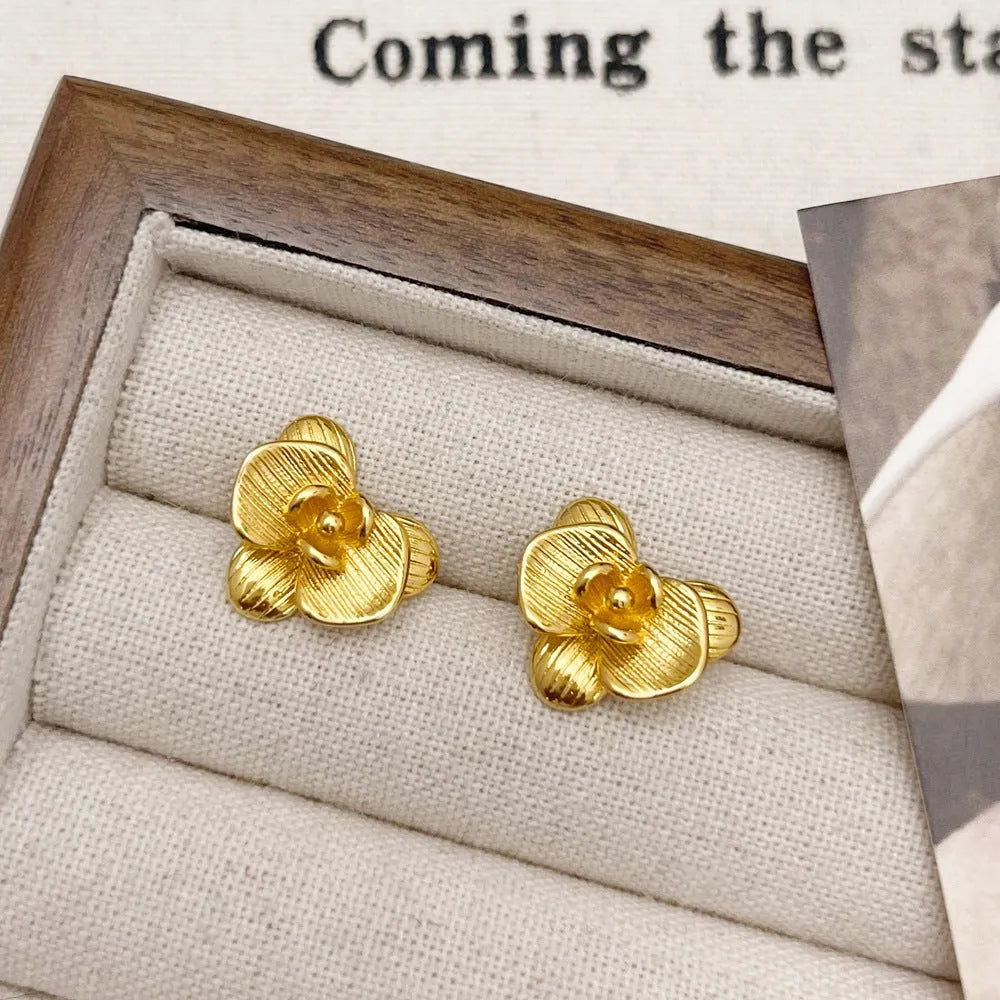 Retro flower earrings in gold or silver with detailed petal design on copper base