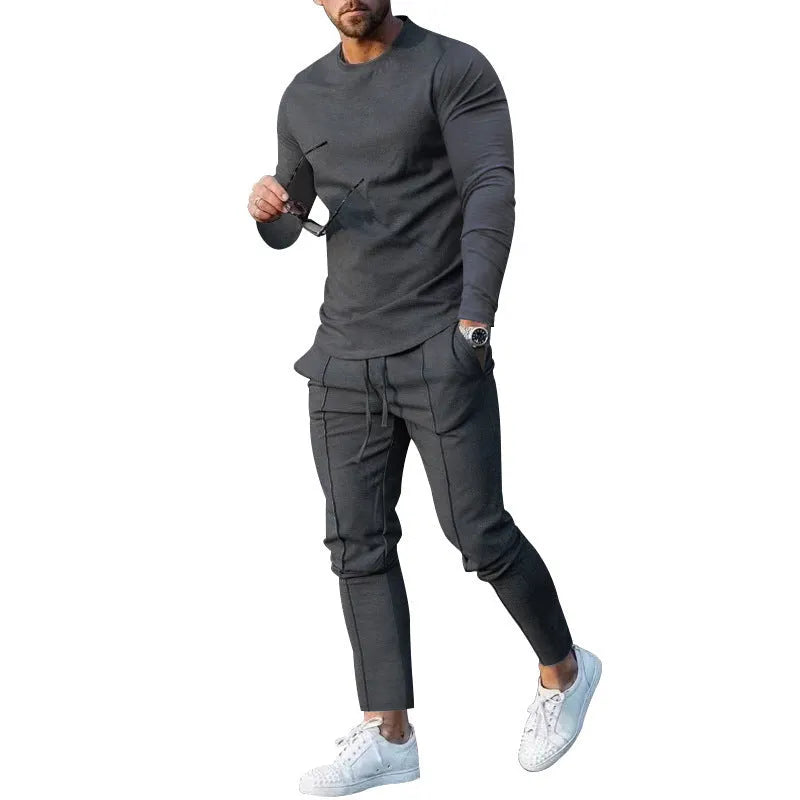 Men's light grey polyester two-piece suit with long sleeve round neck T-shirt and matching trousers laid flat.