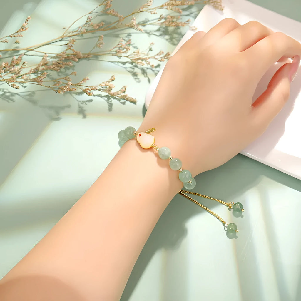 Rabbit charm bracelet with green aventurine or strawberry quartz beads on a gold-coloured adjustable chain.