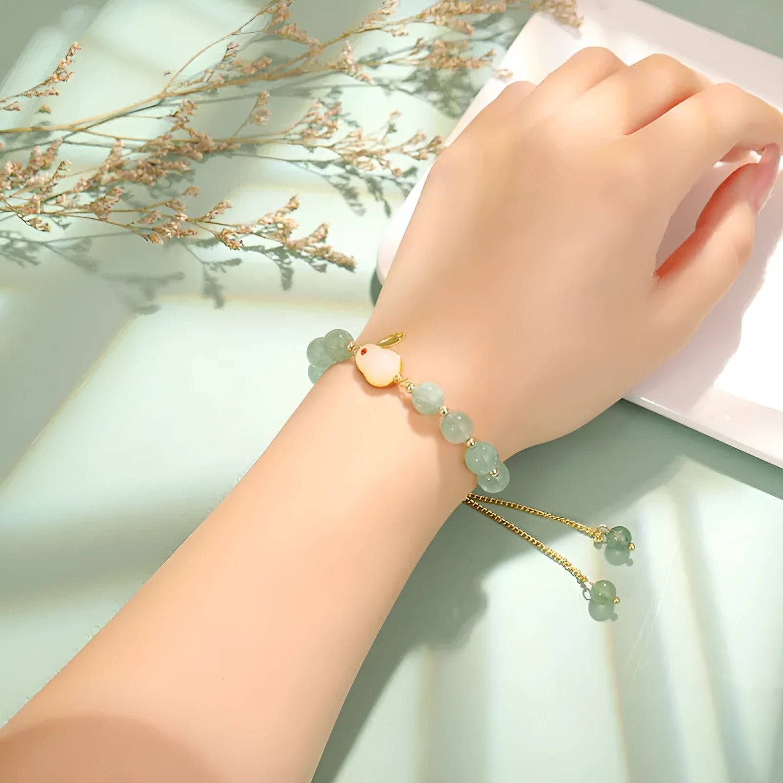 Rabbit charm bracelet with green aventurine or strawberry quartz beads on a gold-coloured adjustable chain.