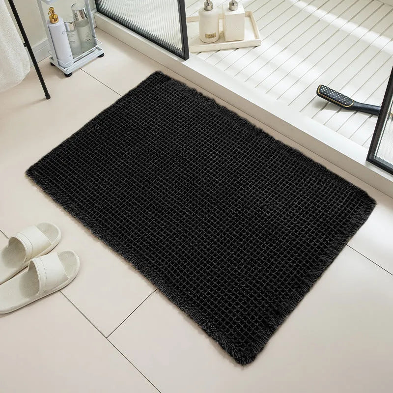 Modern checkered pattern absorbent non-slip bathroom floor mat in a neutral colour on tiled floor.