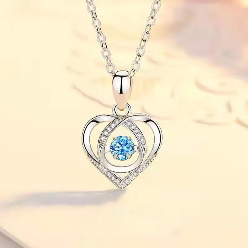 Blue diamond heart-shaped necklace and matching bracelet set with gemstone inlays on a model