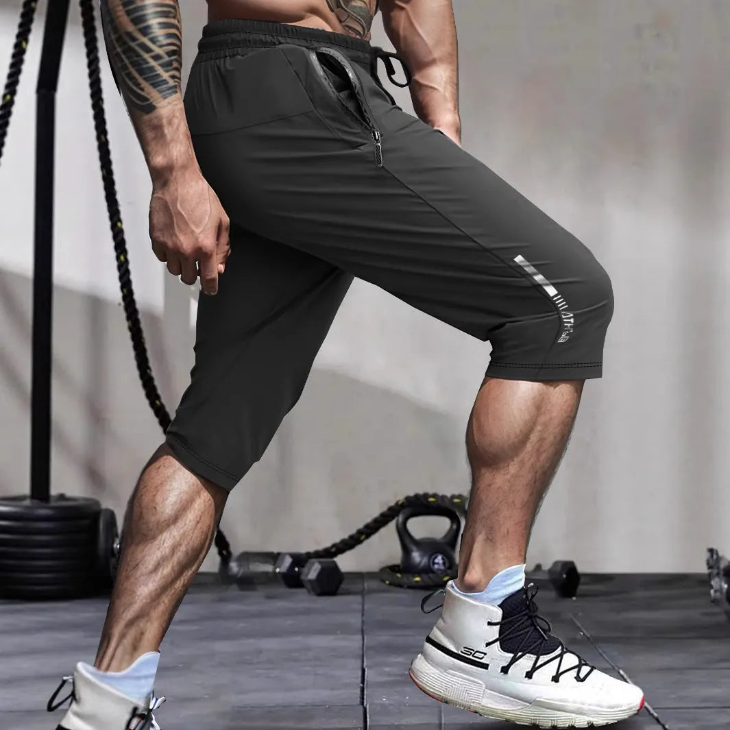 Man wearing black cropped straight-leg sports casual pants made from quick-drying nylon fabric.