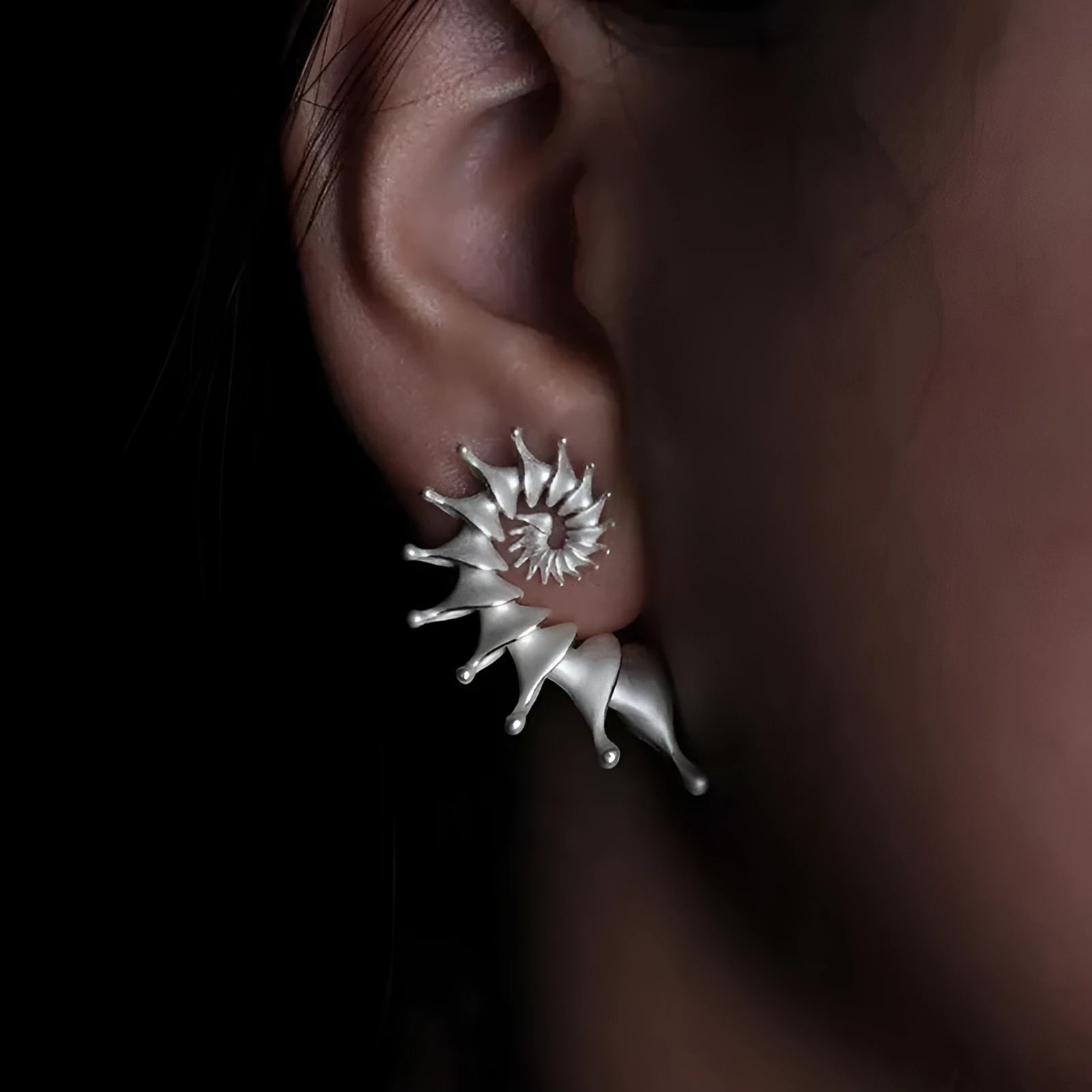 Exaggerated three-dimensional conch shell stud earrings with a matte finish in an irregular abstract design.