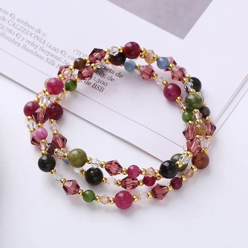 Women's three-ring crystal bracelet with tourmaline, strawberry quartz, and amethyst beads on adjustable cord.
