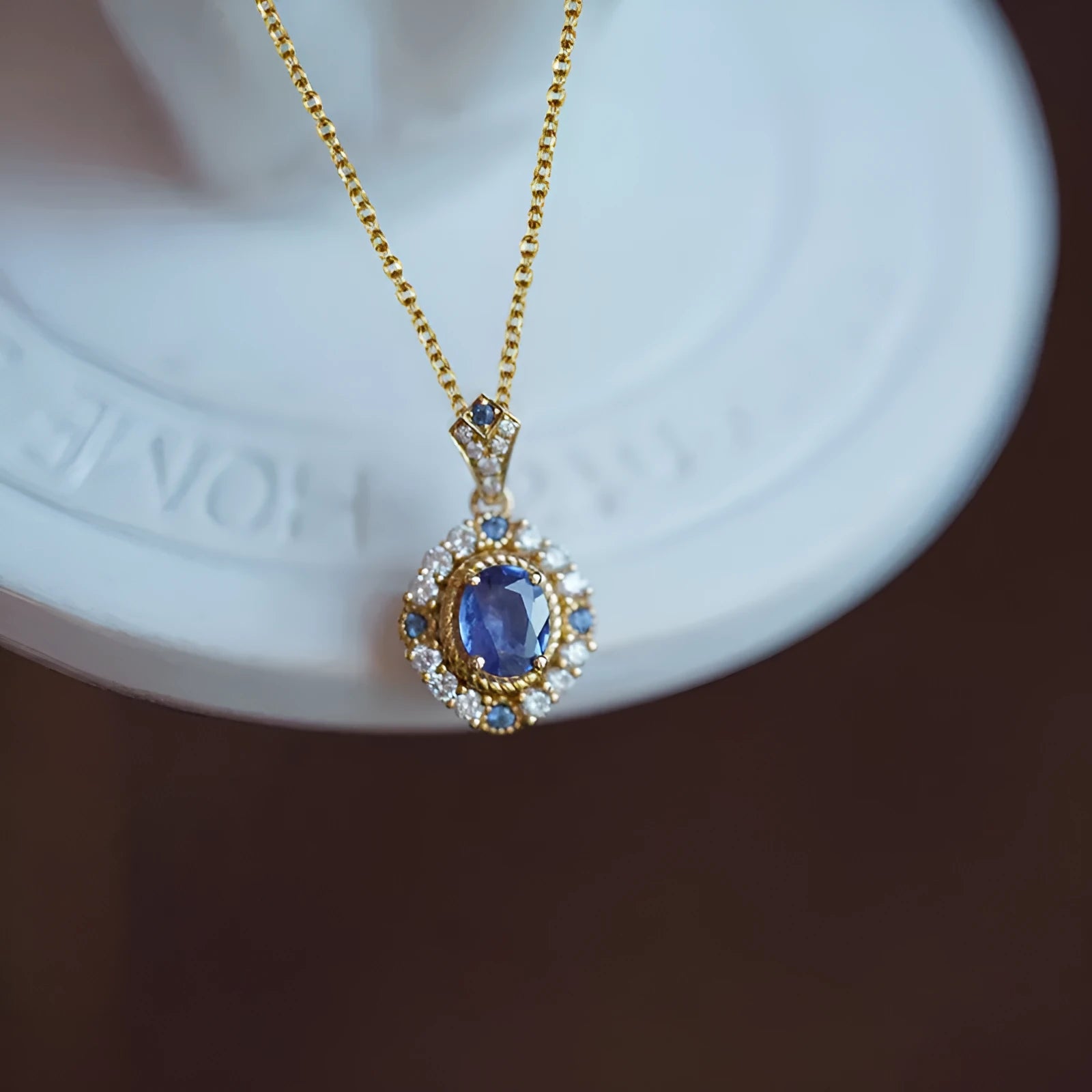 Golden women's necklace with mixed gem inlaid pendant on an adjustable copper box chain.