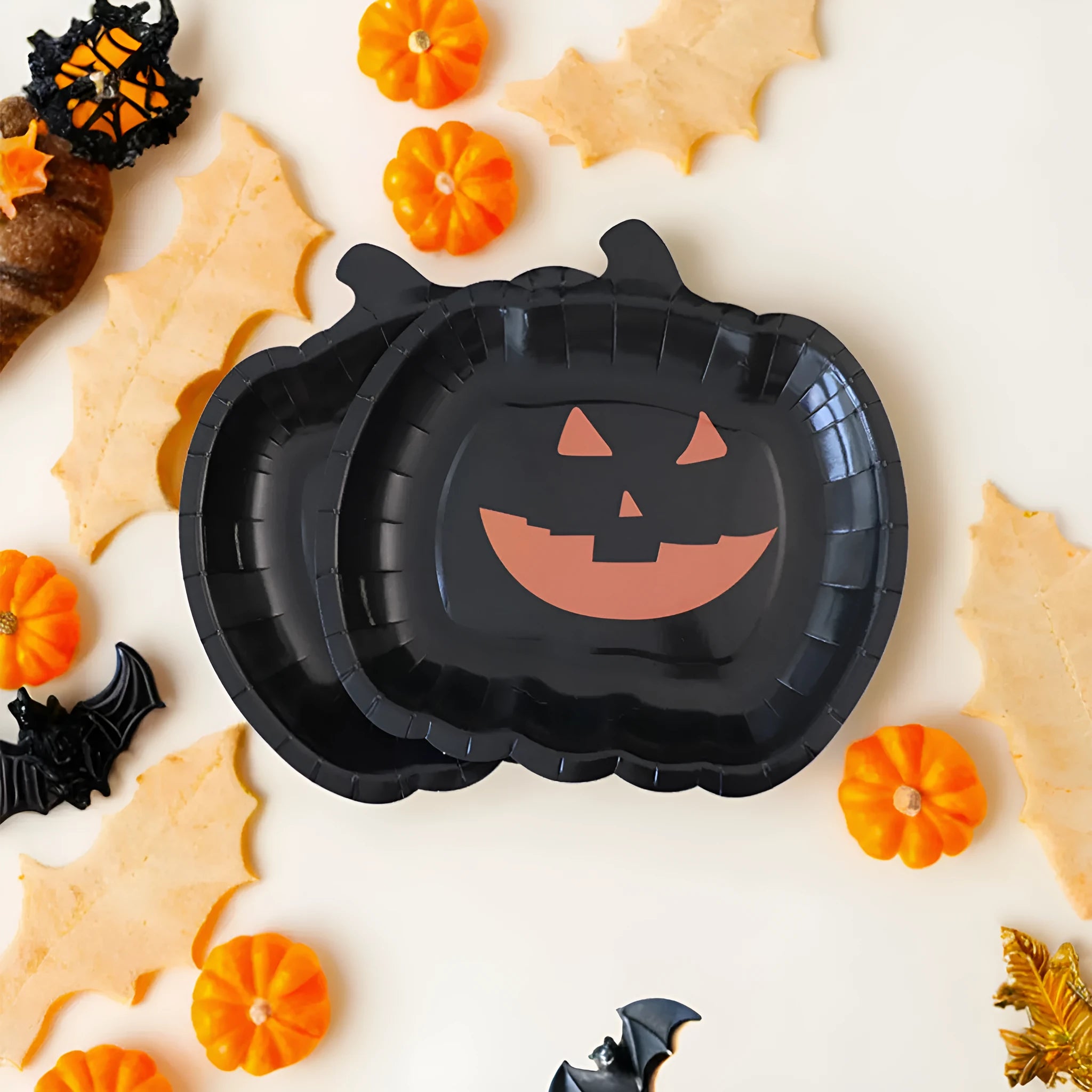 Set of black disposable Halloween paper plates with orange pumpkin design, 9 inches in diameter.