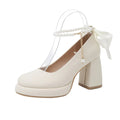 Women's beige Mary Jane shoes with chunky low heel, pearl decoration, and ankle strap buckle on a round toe.