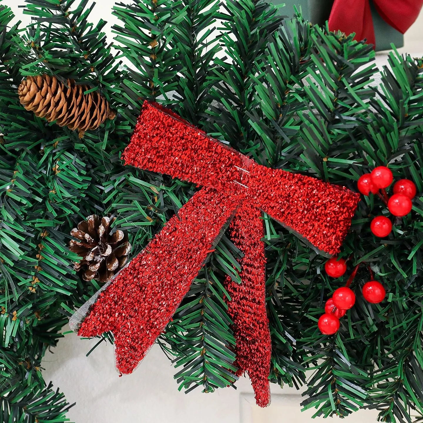 70cm tall Christmas rattan decorative cane with pine cone and red bow, shown on a festive table setting.