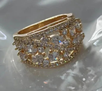 Women's round hollow fashion ring with gemstone accents on a copper band, shown in gold and platinum finishes.