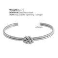 Open C-shaped stainless steel bracelet with knotted double layer design in gold or silver finish.
