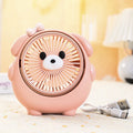 USB desktop electric fan in one of six colours including bear brown and puppy designs on a desk.
