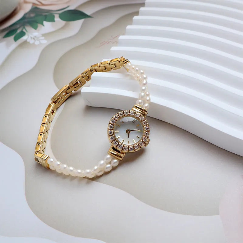 Women's light gold bracelet watch with freshwater pearl accents and round 18mm dial