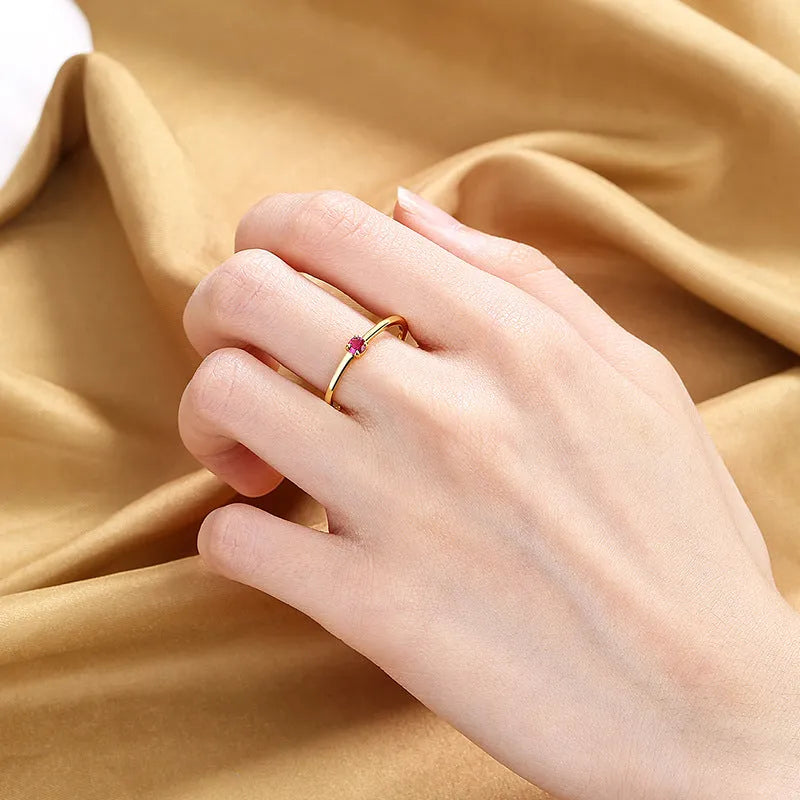 Women's copper fine circle ring with a single diamond in a geometric setting, shown on a hand.