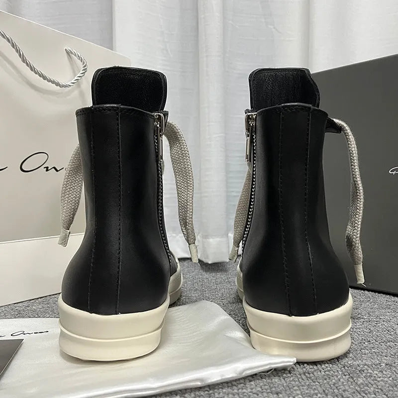 Black high-top leather sneakers with side zipper on a white background.