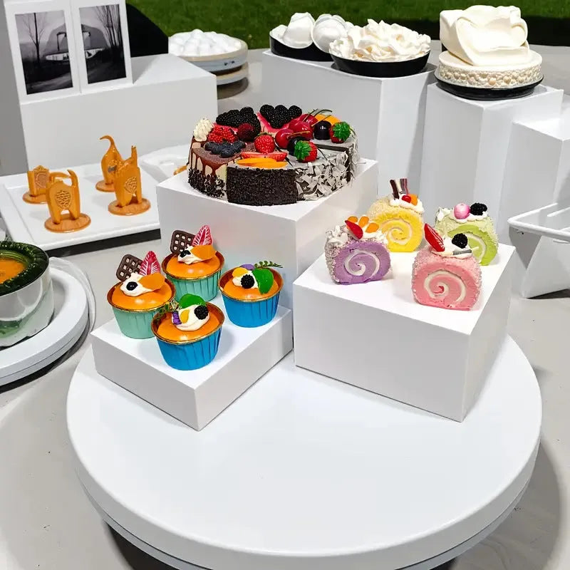 White plastic cube dessert display stand with six modular pieces arranged on tabletop