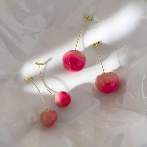 Acrylic peach-shaped dangle earrings with copper findings, shown in small and large size variations.