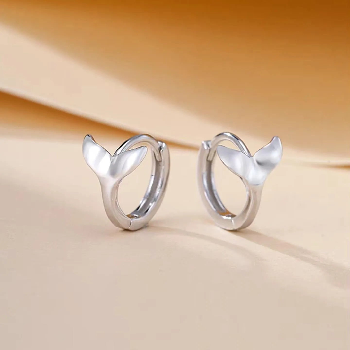 A pair of women's simple fishtail design earrings in an electroplated gold colour.