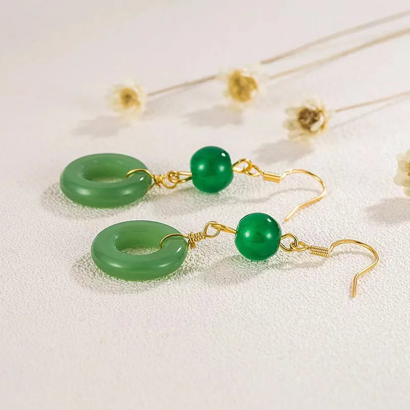A pair of green geometric Peace Buckle-shaped earrings inspired by traditional Chinese cheongsam design.