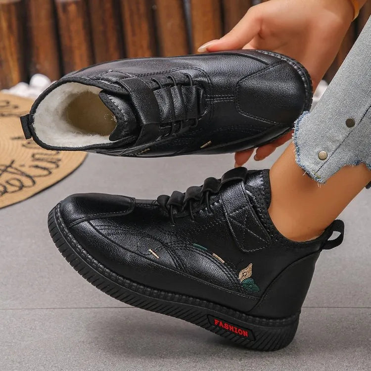 Women's black velvet low-cut indoor slippers with a non-slip rubber sole and decorative hollow out details.