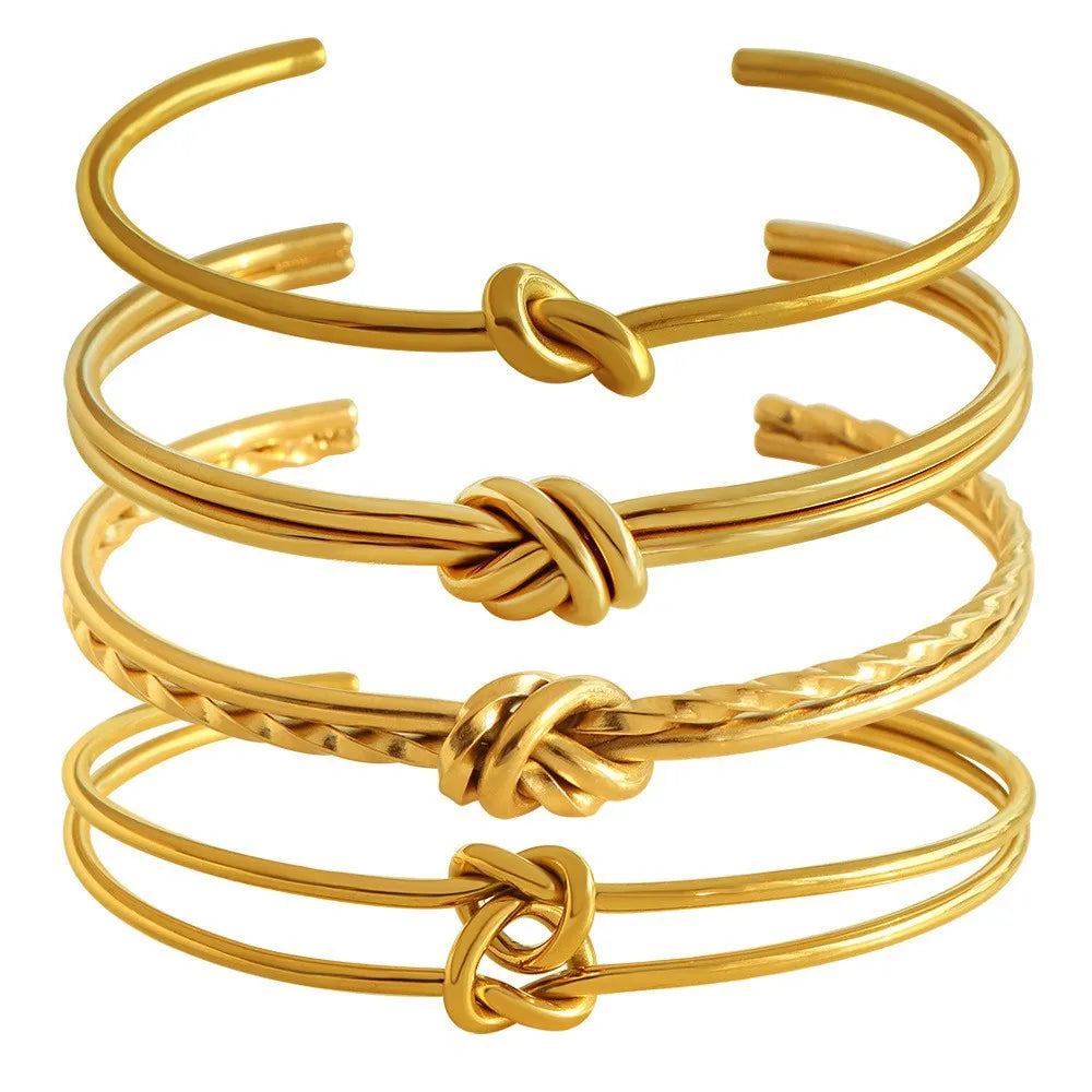 Open C-shaped stainless steel bracelet with knotted double layer design in gold or silver finish.