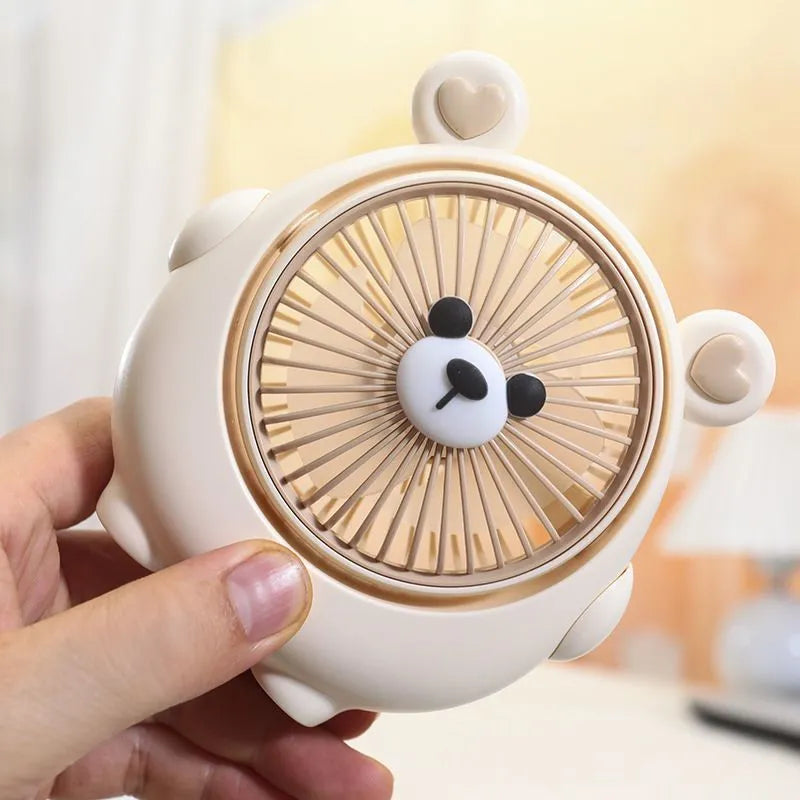 USB desktop electric fan in one of six colours including bear brown and puppy designs on a desk.