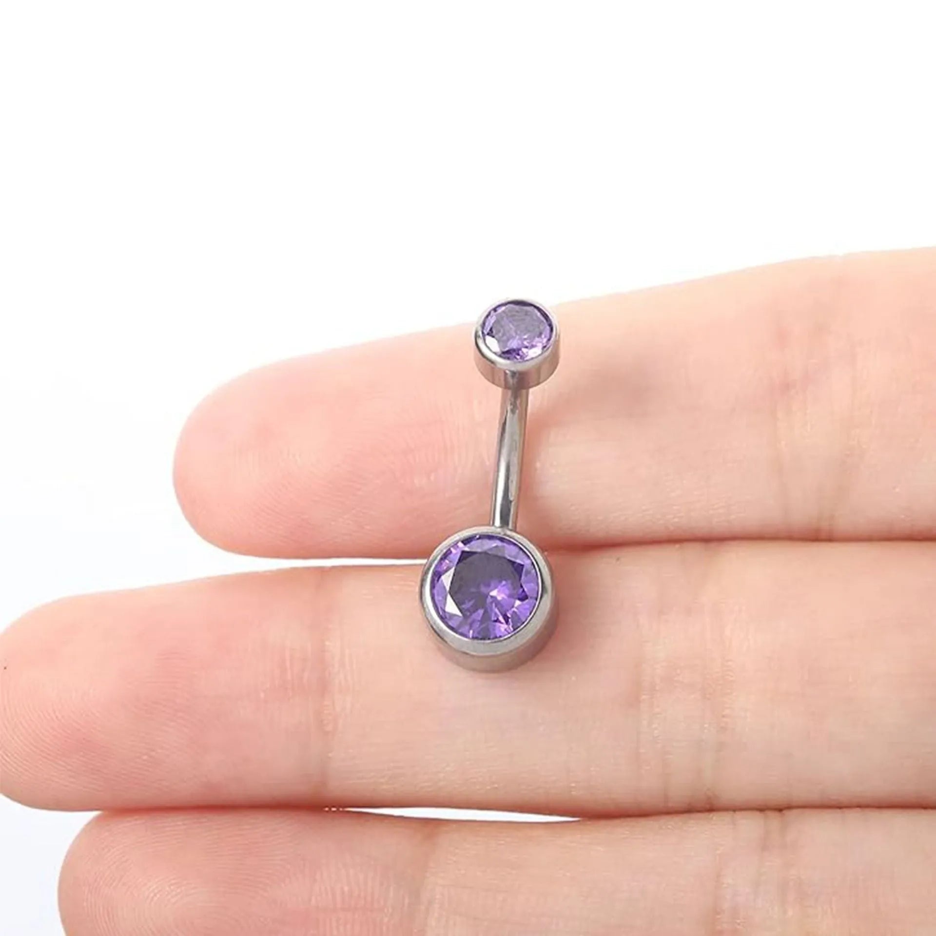 Double-headed zircon titanium alloy navel stud body jewellery on a white background.