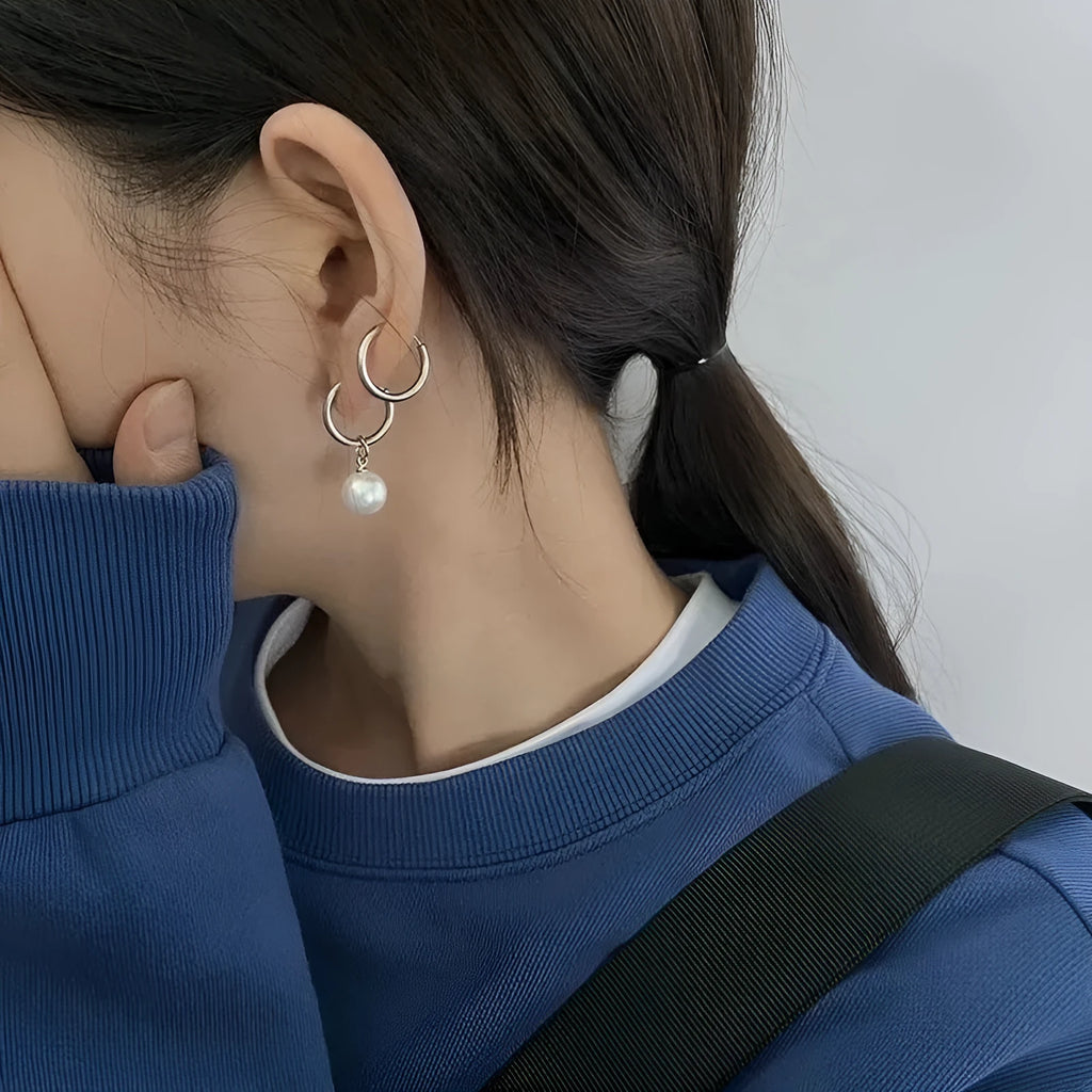 A pair of women's geometric pearl hoop earrings with alloy construction and titanium steel posts.