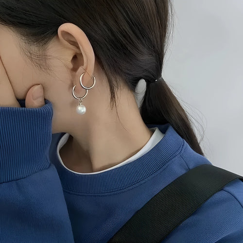 A pair of women's geometric pearl hoop earrings with alloy construction and titanium steel posts.