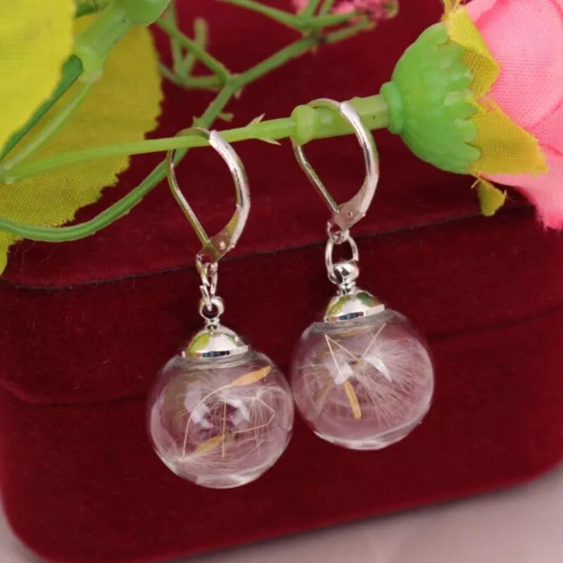 Transparent glass ball earrings with dandelion seed design and French hooks in silver or bronze finishes