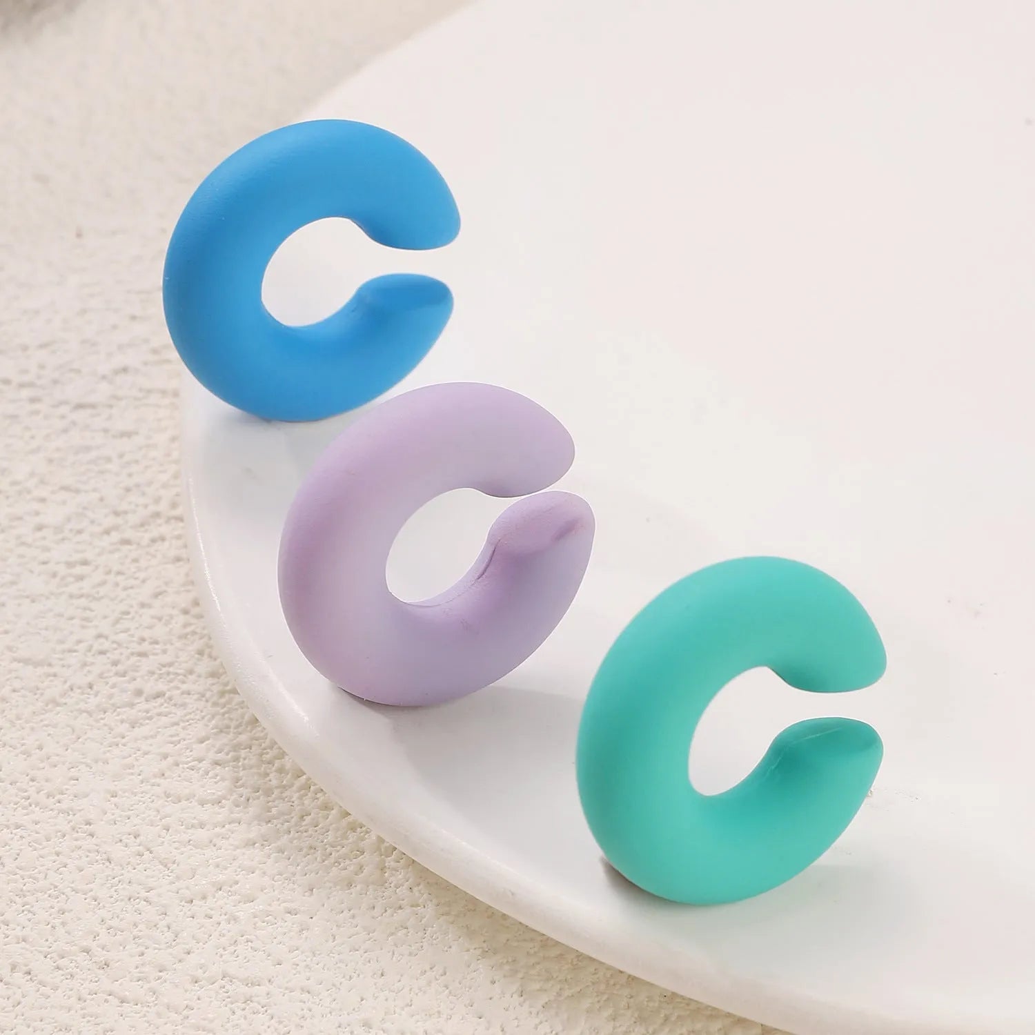 Matte finish geometric C-shaped clip-on earrings in candy colours for women without pierced ears